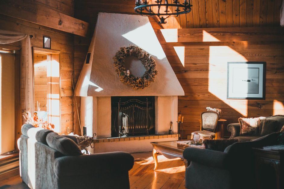 Gemütliches Wohnzimmer mit Decken und Kerzen.